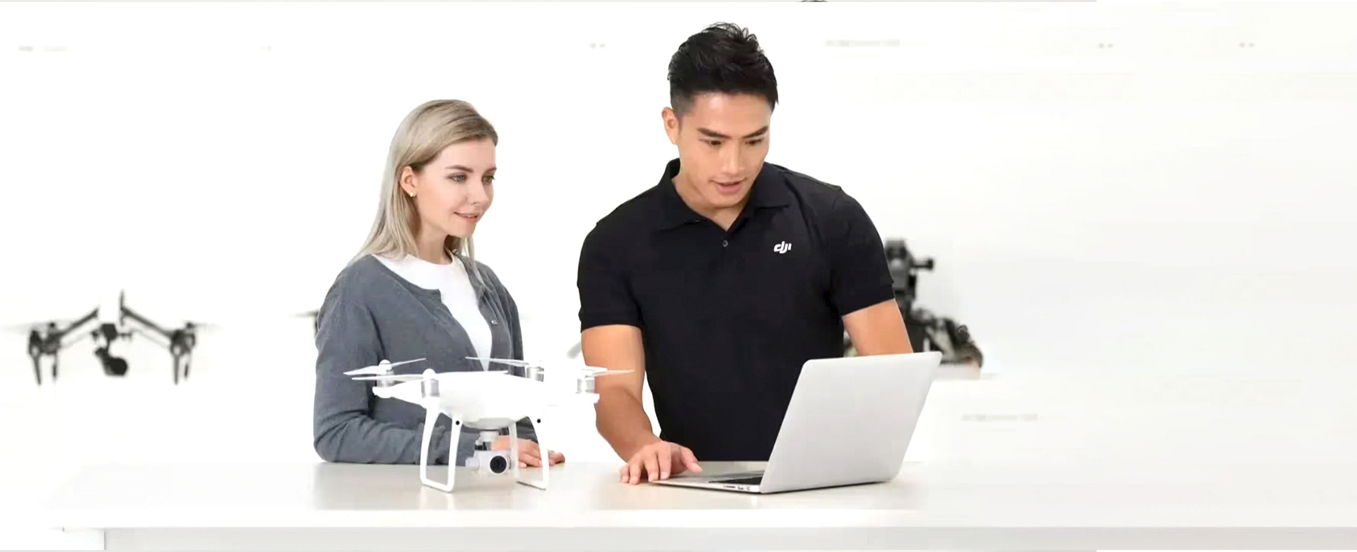 A DJI representative helps a customer register their Phantom to the DJI Care Refresh service using a laptop.