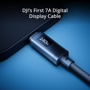 A close-up of a dark blue braided display cable plugged into the side of a smartphone, with the text 'DJI's First 7A Digital Display Cable' at the top on a blue gradient background.