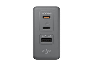 A gray dual-port USB charger with two USB-C ports, one labeled 140W MAX and 5A, and another labeled 33W MAX, featuring the DJI logo on a plain white background.