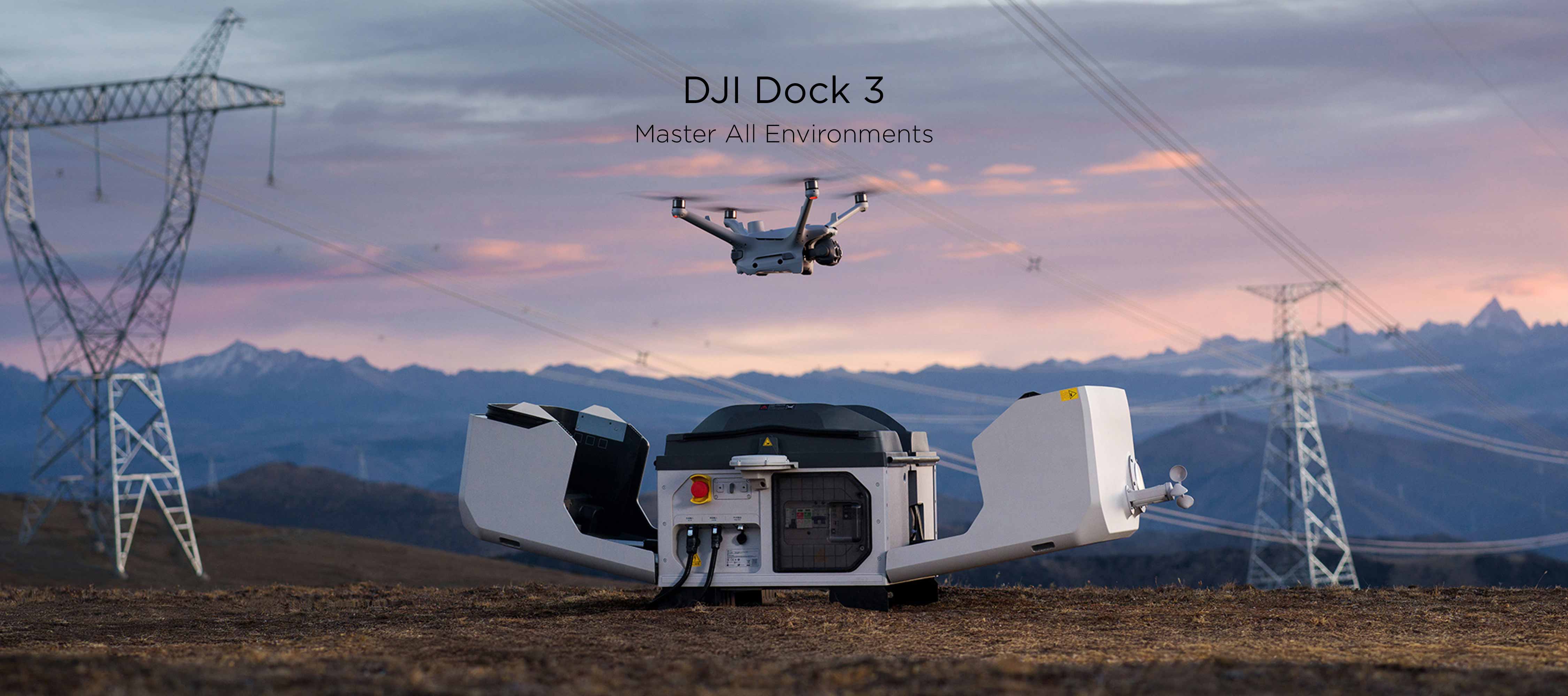 A Matrice 4TD hovers above the DJI Dock 3 resting on a field with mountains and powerlines in the background.