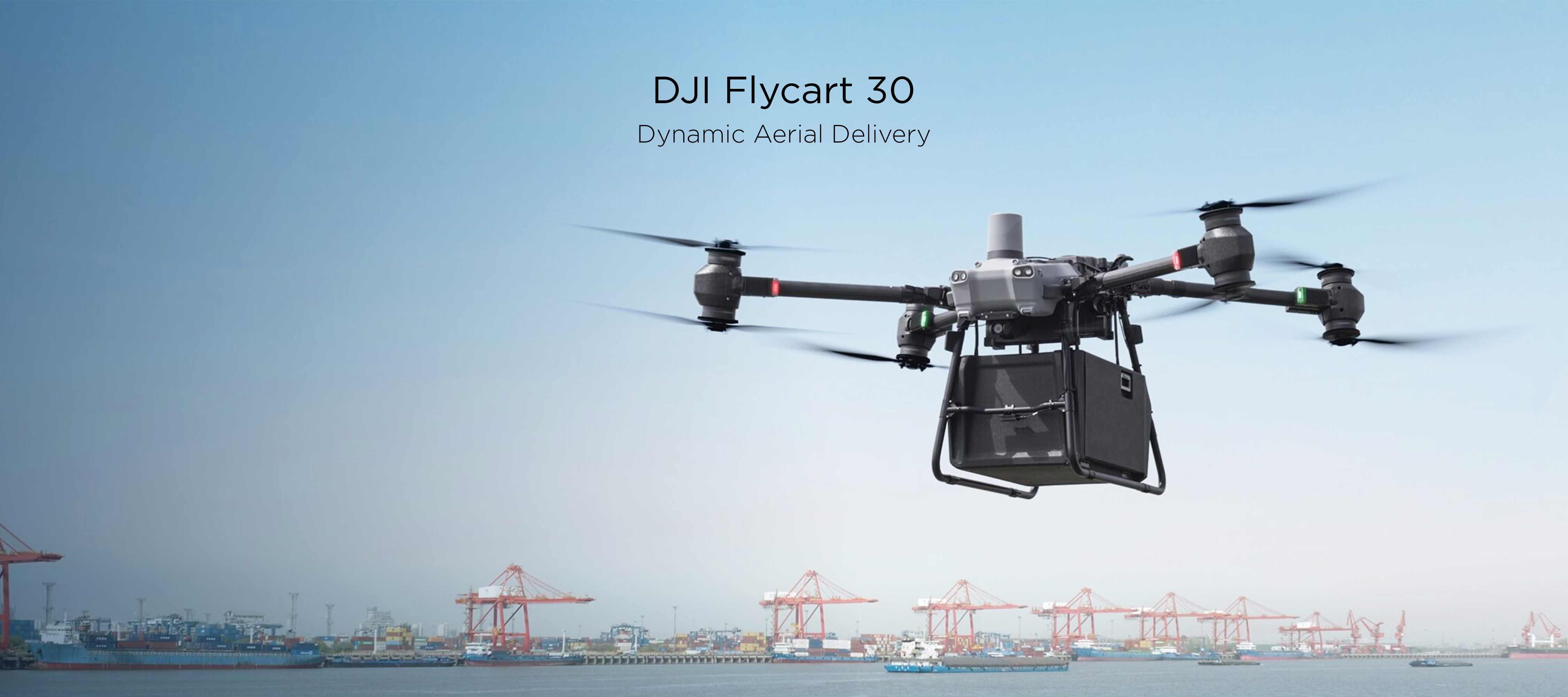 A DJI Flycart 30 transports a large container while cargo ships sail in the background.